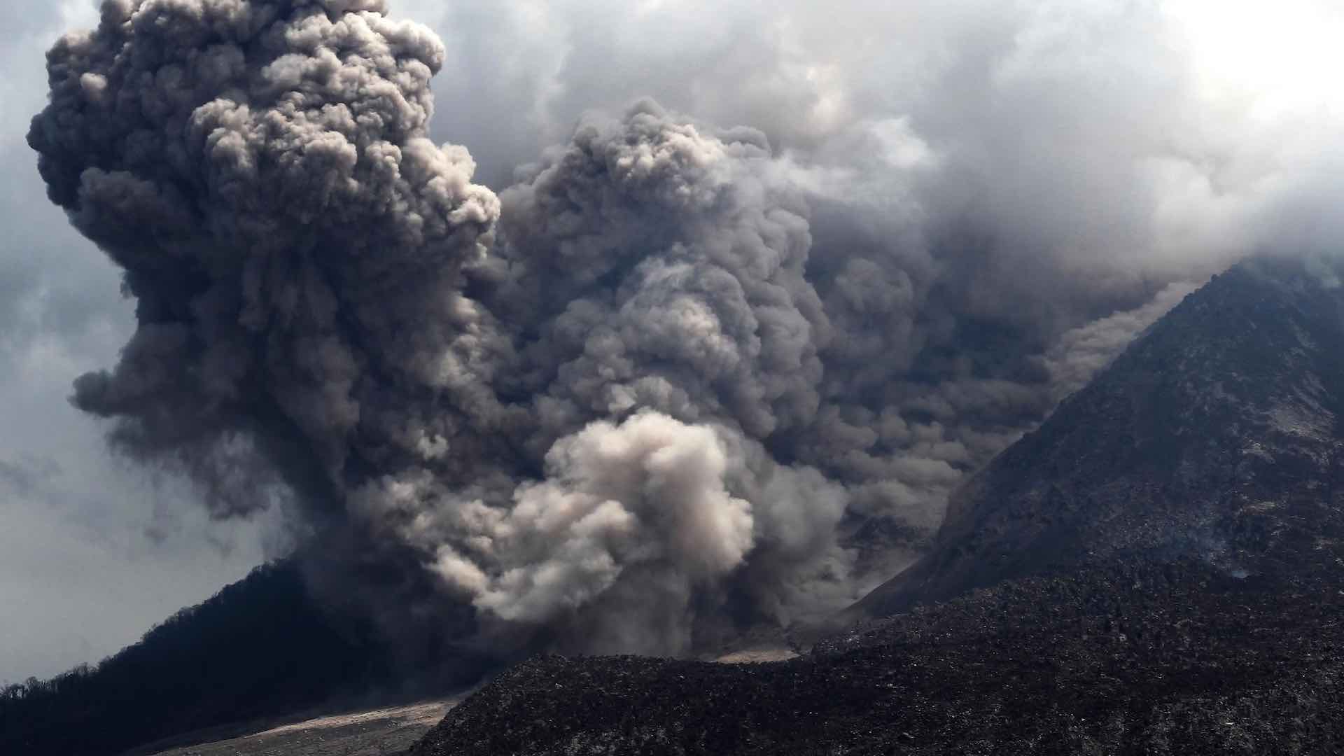 انڈونیشیا کا روانگ آتش فشاں زندگی کے لیے گرجتا ہے، آسمانی بجلی چمک رہی ہے۔